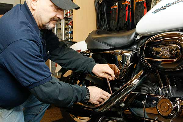 Motorcycle technician performing repairs at Total Cycle in Rochester, NY